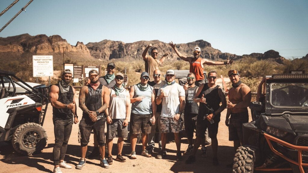 A group of men from the Uncaged Men’s Accountability Group standing together in the desert after an off-road adventure, symbolizing resilience, leadership, and mastering mindset.