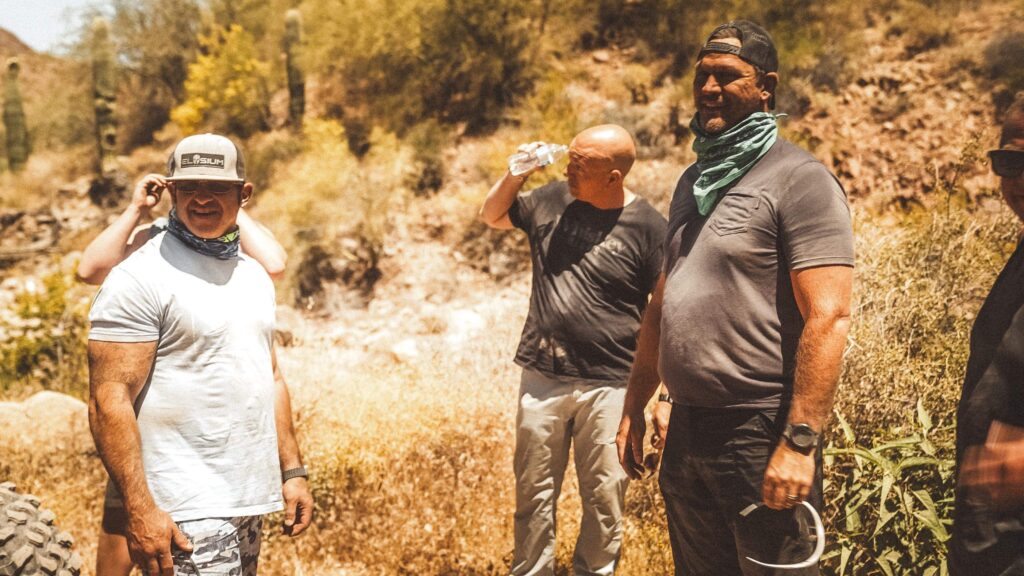 A group of men stand together in the desert heat during an Uncaged Men’s Accountability Group retreat, embracing personal accountability and self-improvement.