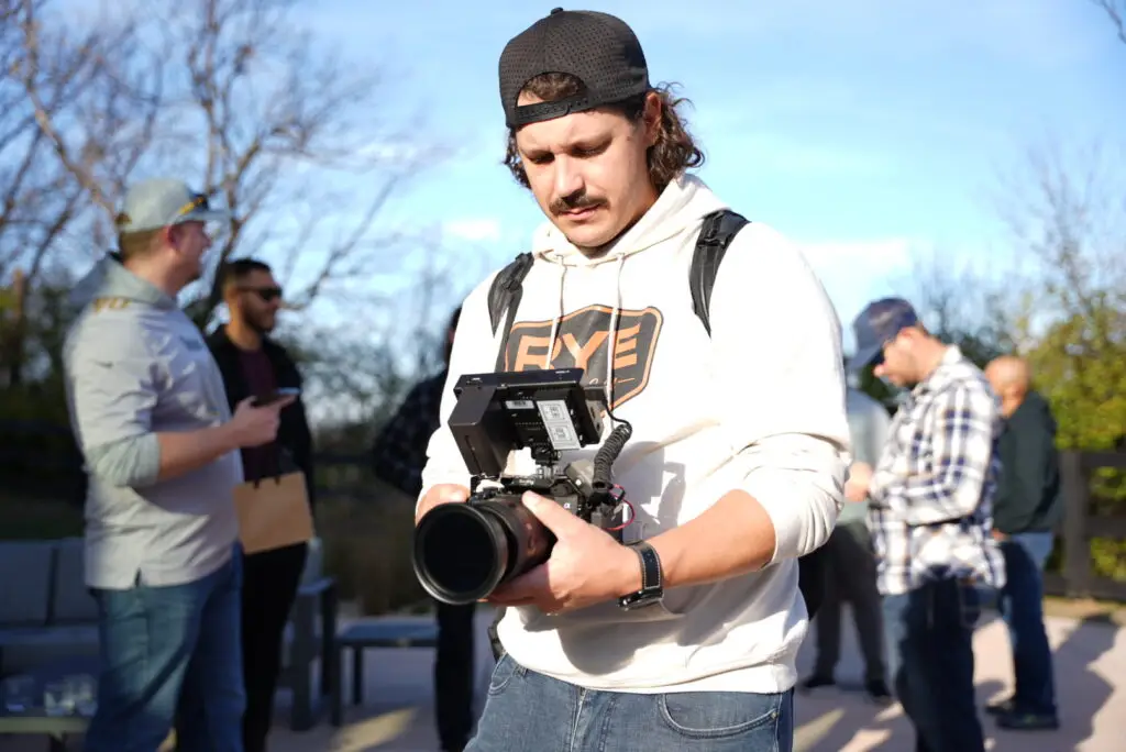 Videographer capturing content at an Uncaged event, focusing on authenticity, storytelling, and documenting real success.