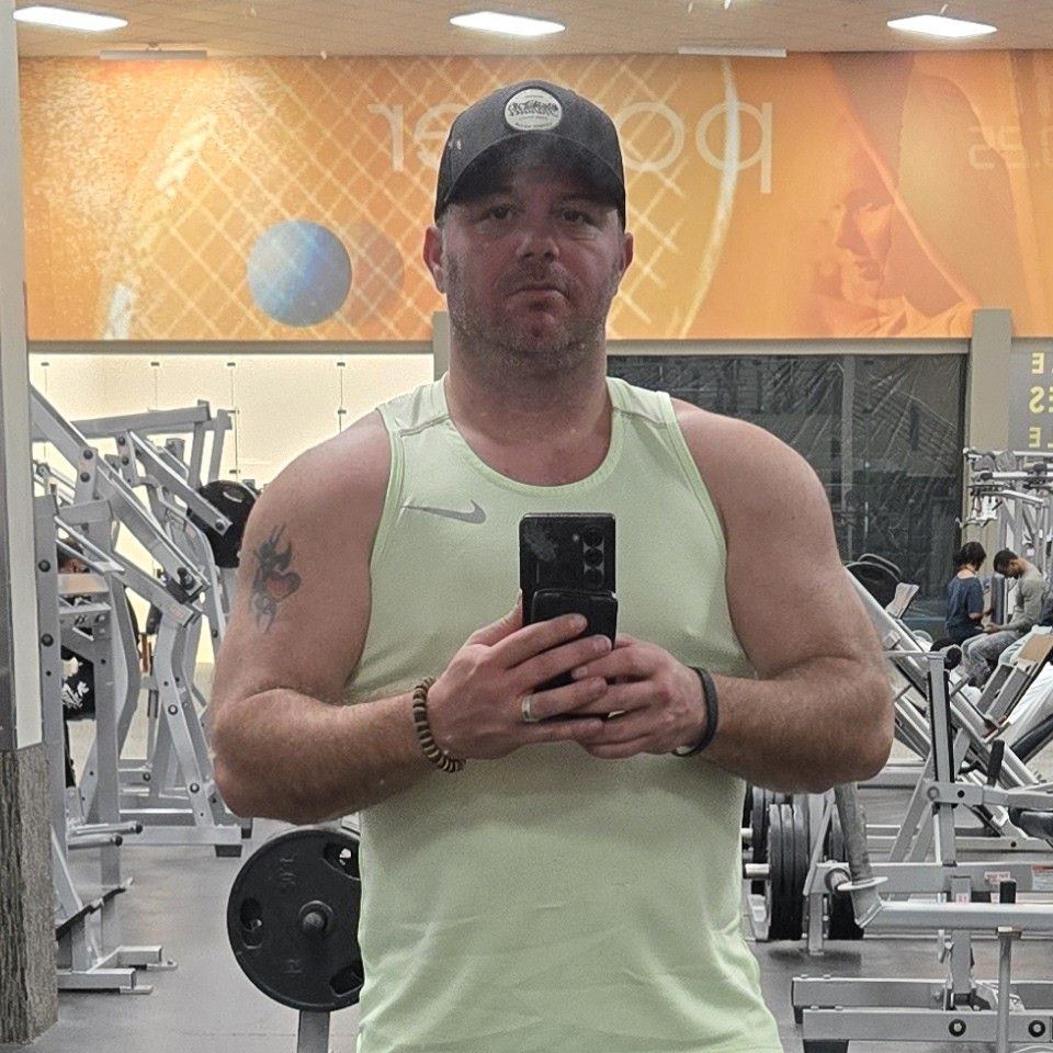 Tony Dayton taking a gym mirror photo during a strength training session, representing discipline, accountability, and personal growth through the Uncaged Men’s Only Accountability Group.